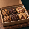 Six assorted cookies in a selection box, including a Nutella-filled cookie with plain golden dough